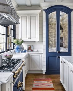 a kitchen with white cabinets and blue trim on the doors is pictured in this image