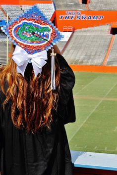 a woman wearing a hat with the university of florida gators on it at a football game