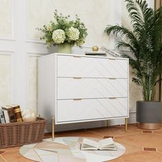 a white dresser sitting next to a potted plant