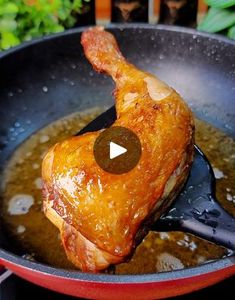 a chicken in a pan being cooked with a spatula