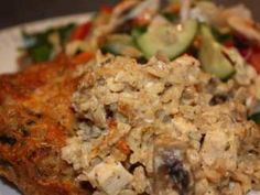 a white plate topped with meat covered in toppings next to a salad and cucumber