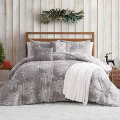 a bed with grey and white comforters in a bedroom