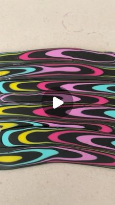 a skateboard with multicolored swirls on the bottom and black, yellow, pink, blue, green, purple, red