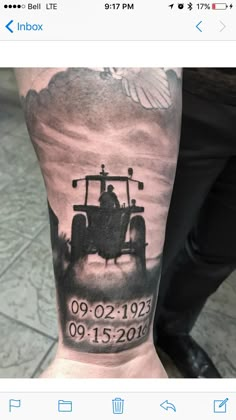 a man's arm with a tractor and date tattooed on the back of it