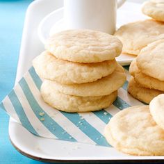 a stack of white cookies sitting on top of a table next to some crackers