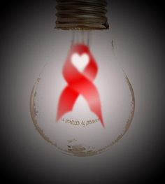 a light bulb with a red ribbon in the shape of a heart and words on it