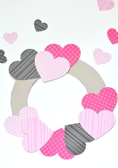 valentine's day wreath made out of paper hearts on a white table with pink and gray polka dots