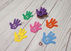 several colorful hand prints on a white wooden surface