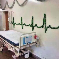 a hospital bed in a room with green string art on the wall