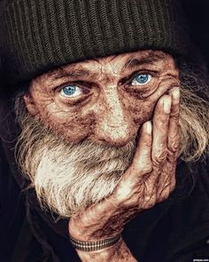 a painting of an old man with blue eyes and a long white beard wearing a beanie