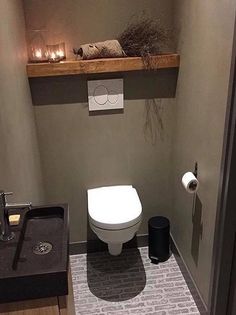 a small bathroom with a toilet and some candles