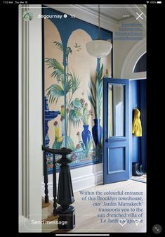 an entry way with blue doors and paintings on the wall behind it, along with wooden flooring