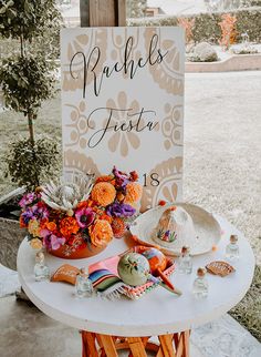 a table with flowers on it and a sign that says mardi gras fiesta