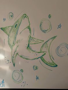 a drawing of a shark with stars and circles on it's back side in green ink