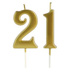 a gold cake topper with the number twenty two on it's side, in the shape of a candle