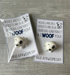 two white dog magnets sitting on top of a wooden table next to each other