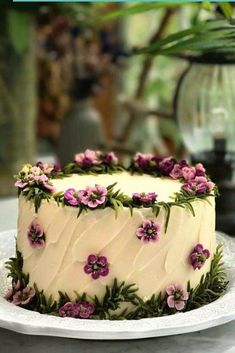 a white cake with purple flowers on it