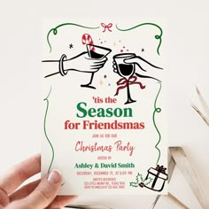 someone holding up a christmas party card with the words tis the season for friends on it