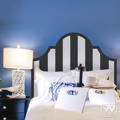 a bedroom with blue walls and white bedding