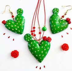 three pieces of green and red jewelry on a white surface