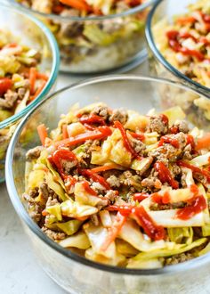 four glass bowls filled with food on top of a white countertop next to each other