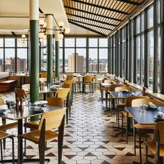 an empty restaurant with large windows overlooking the city