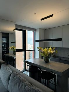 a living room filled with furniture and a large window next to a dining table covered in flowers