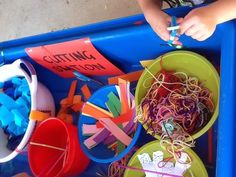 a blue tray filled with lots of different types of crafting supplies and paper straws