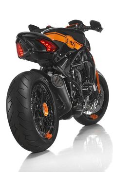 an orange and black motorcycle parked on top of a white floor