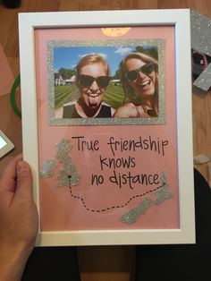 someone holding up a framed photo with the caption true friends know no distance