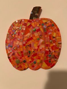 an orange mosaic pumpkin hanging on the wall