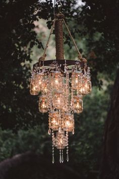 a chandelier hanging from a tree with lots of lights on top of it