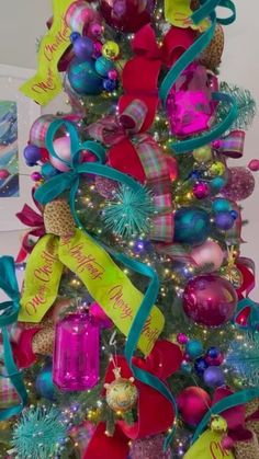 a colorful christmas tree decorated with ornaments and ribbons