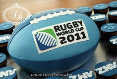 a football cake with cupcakes in the shape of it and rugby world cup logo on top