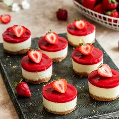 strawberry cheesecakes are arranged on a tray with strawberries