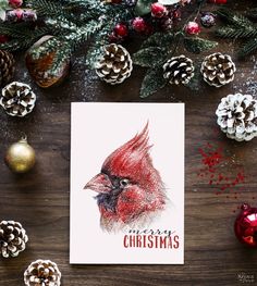 a christmas card with a red cardinal on it next to pine cones and other holiday decorations