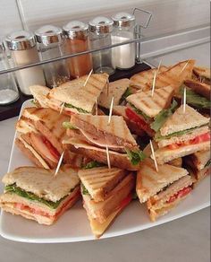 a white plate topped with lots of sandwiches