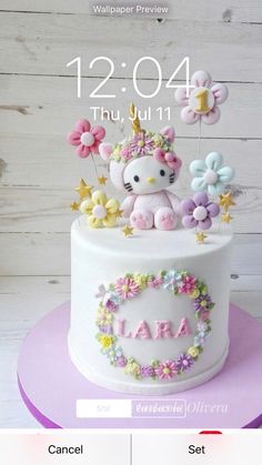 a hello kitty cake decorated with flowers and a unicorn