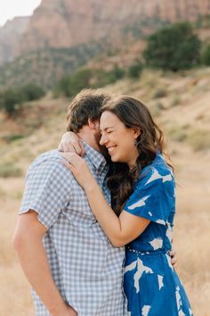 a man and woman embracing each other in the desert