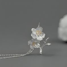 Introducing our exquisite pendant featuring a delicate design of cherry blossoms crafted in sterling silver. The intricate details of the flowers are beautifully highlighted with gold plating on the stamens, adding a touch of elegance and sophistication. The pendant captures the essence of spring, symbolizing renewal and beauty. It hangs gracefully from a matching sterling silver chain, making it a timeless accessory suitable for any occasion. Cherry Blossom Jewelry, Cherry Blossom Necklace, Chain Making, Delicate Design, Exclusive Jewelry, Timeless Accessories, Cherry Blossoms, Sterling Silver Chain, Intricate Details