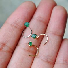 "These natural and genuine rough Emerald nose pins, handset in solid 14k gold are a piercing lovers delight. A perfect matching gift for mother-daughter, bffs, siblings, bride & bridesmaids! * Stone: Natural Emerald * Cut: Rough/Raw * Gemstone Size : 2-3mm (approx.) * Wire - 20 AWG (0.82 mm) / 22g (0.6 mm) * Style : C/L Wire, Flatback, Screw back (Please select from dropdown) * Style - Standard Post Length - Gauge - AWG (can be made as per requirement) - C/L Wire Twist - 5-6mm (head to bend) Nose Jewels, Diamond Nose Stud, Nose Pins, Nose Pin, Nose Jewelry, Gold Alloys, Nose Rings, Nose Ring Stud, Matching Gifts