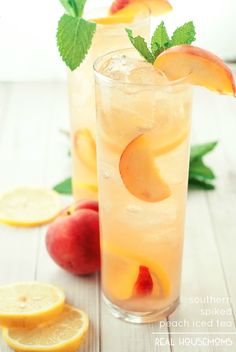 two tall glasses filled with peach iced tea and sliced peaches on a white table