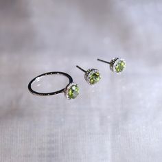 "These stylish earrings have a stunning bright color and the Peridot is surrounded by a halo of shimmering diamonds. Perfect as a gift for girlfriend or wife or mother. Features * Made to Order. * Metal: 925 Sterling Silver * Custom Color: Silver, Gold, Rose Gold * Main Stone: Peridot, 5mm dia Round Shape, 2pcs * Side Stone: Cubic Zirconia Peridot Ring: * Halo Ring: https://etsy.me/2Z81vl7 * Bypassing: https://etsy.me/32VsKR4 Be sure to hit \"favorite\" on the right so it remains in your favorit Birthstone Engagement Rings, Peridot Jewelry, Peridot Earrings, Ring Halo, Stylish Earrings, Halo Earrings Studs, Peridot Ring, Peridot Gemstone, Stylish Earring