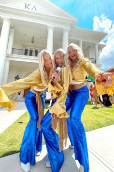 three women in blue and yellow outfits posing for the camera