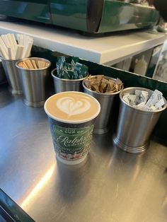 three cups of coffee sitting on top of a metal counter