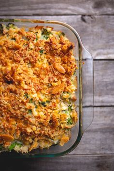 a casserole dish with chicken and broccoli in it on a wooden table