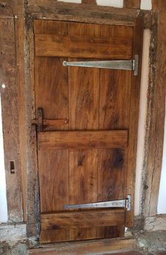 an old wooden door with a metal handle on the bottom and side bars to it