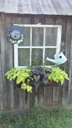 a window box with plants in it and a bird decoration on the window sill