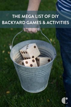 a person holding a bucket full of wooden dices