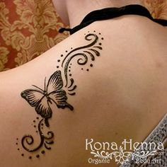 the back of a woman's shoulder with a butterfly tattoo on her left side